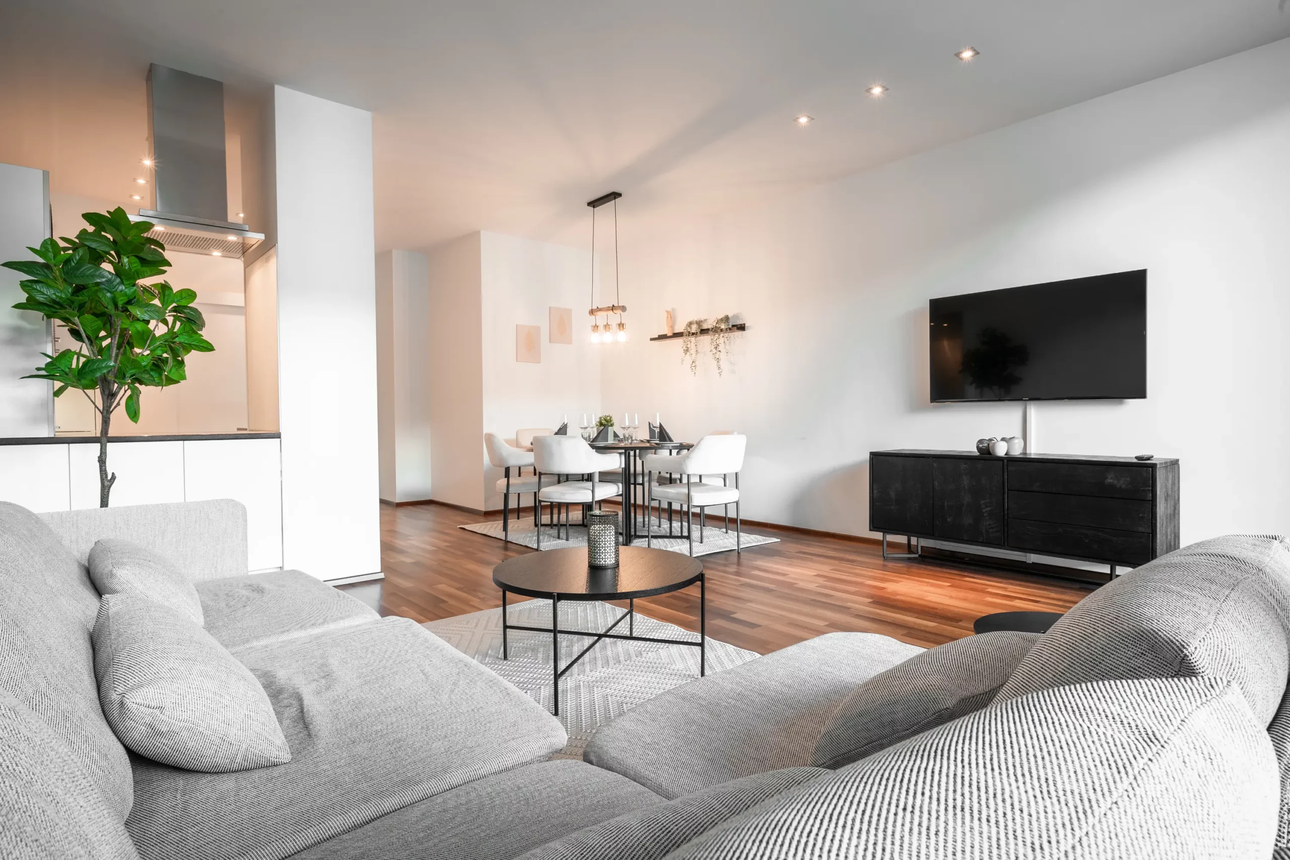 Moderner Wohnbereich im CityFLAT 38 Appartement by globboard in Schladming-Dachstein, mit gemütlicher Couch, Esstisch und Flachbildfernseher.