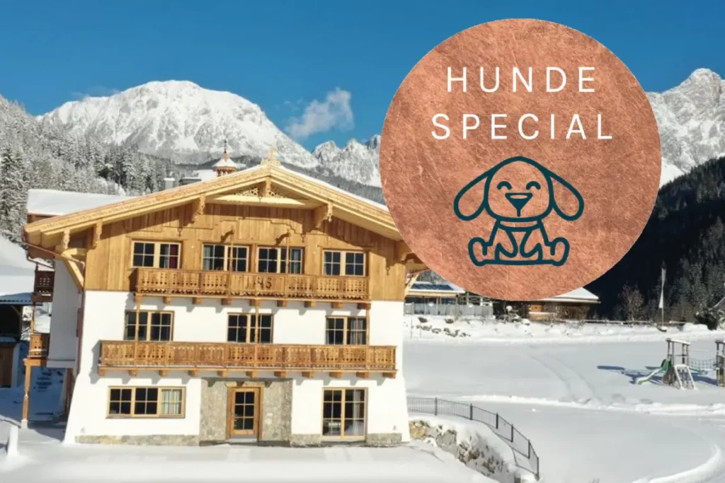 Das Ferienhaus Mandlberggut in einer schneebedeckten, alpinen Landschaft, hervorgehoben mit dem „Hunde Special“-Badge, das eine Hundegrafik und den Text „Hunde Special“ zeigt.