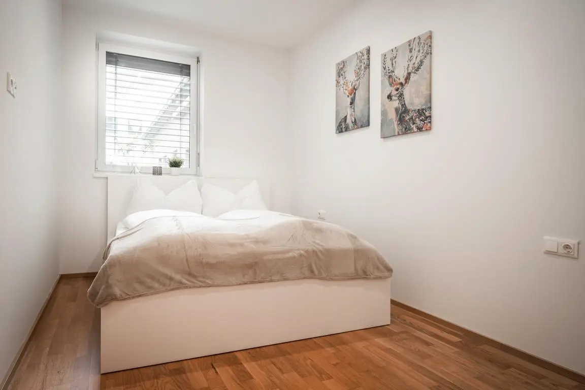 Gemütliches kleines Schlafzimmer mit Doppelbett im CityFLAT 38 Appartement by globboard in Schladming-Dachstein, ideal für einen erholsamen Bergurlaub.